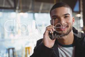 Portrait of man talking on phone in cafe