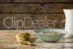 Banana with breakfast cereal on wooden table