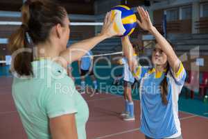 Female volleyball player practicing with coach