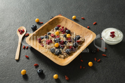 Plate of breakfast cereal and yogurt on black background