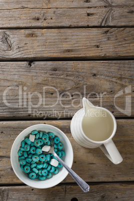 Bowl of froot loops and marshmallow with milk jug