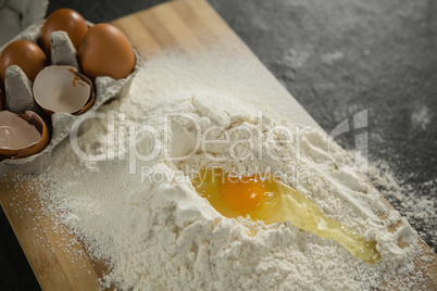 High angle view of egg yolk in flour ny carton on cutting board