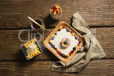Various fruit cereals and honey on a wooden table