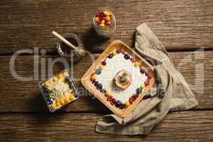 Various fruit cereals and honey on a wooden table