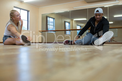 Full length of dancers stretching on floor