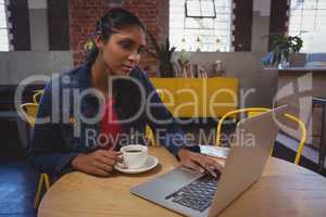 Young woman using laptop in cafe