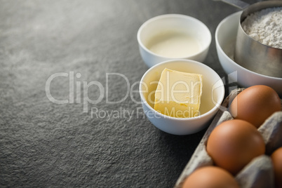Close up of egg carton by butter in bowl