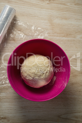 Overhead view of dough in pink bowl