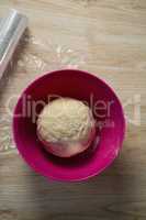 Overhead view of dough in pink bowl