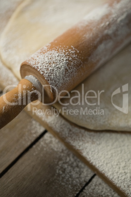 Close up of rolling pin on rolled dough over cutting board
