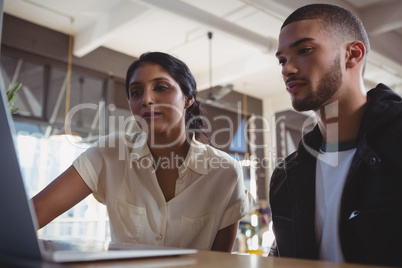 Couple looking into laptop in cafe