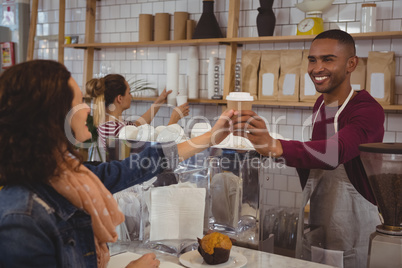 Owner serving coffee to woman