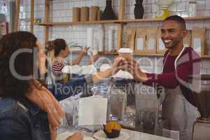 Owner serving coffee to woman