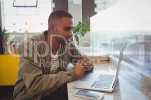 Businessman looking into laptop at counter