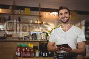 Portrait of waiter with digital tablet in cafe