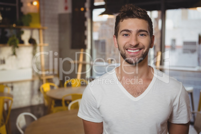 Portrait of smiling waiter at cafe