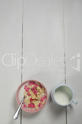 Bowl of honeycomb cereal and milk on wooden table