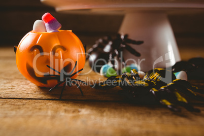 Decorations with candies on wooden table during Halloween