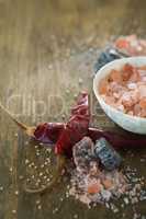 Himalayan salt with spices on wooden table