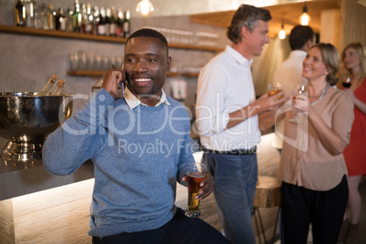 Man talking on mobile phone while having beer