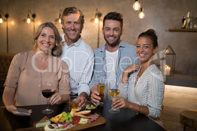 Portrait of happy friends having drinks and meal