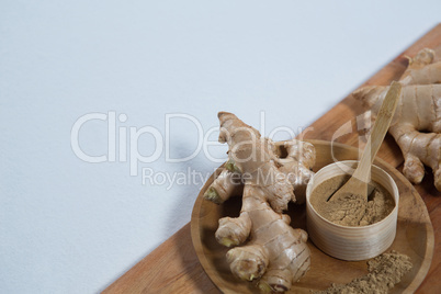 High angle view of organic gingers and powder on serving board