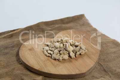 High angle view of dried gingers on wooden heart shape board over burlap