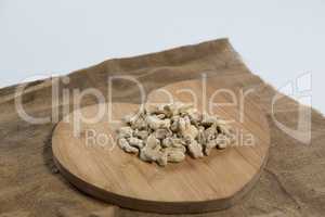 High angle view of dried gingers on wooden heart shape board over burlap