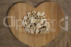 Overhead view of dried gingers on heart shape board over burlap