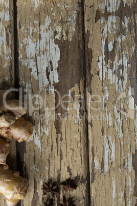Directly above view of fresh gingers and star anise on weathered table