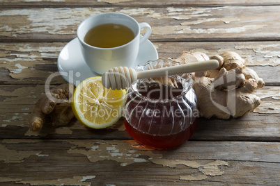 High angle view of fresh honey and lemon with ginger tea on table