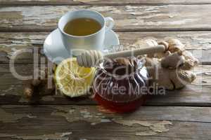 High angle view of fresh honey and lemon with ginger tea on table
