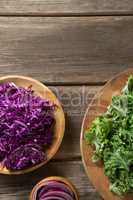 Fresh kale leaves with red cabbage in wooden plates