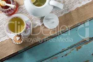 High angle view of ginger tea in cup by honey on burlap