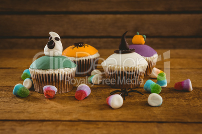 Halloween cup cakes and candies on table