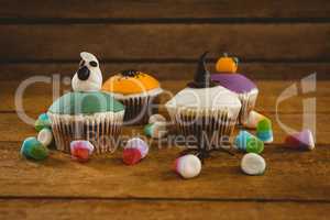 Halloween cup cakes and candies on table