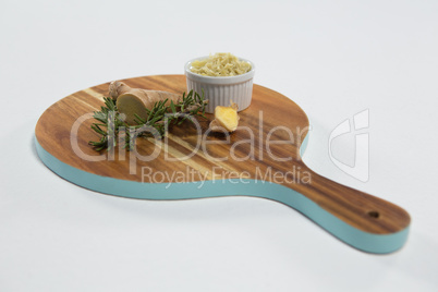 High angle view of rosemary and ginger on wooden serving board