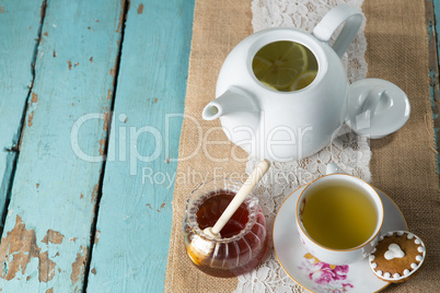 Ginger tea in cup with honey on burlap
