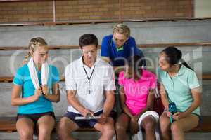Volleyball coach discussing over clipboard with female player