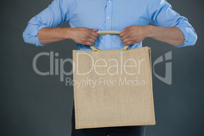 Man holding shopping bag against grey background