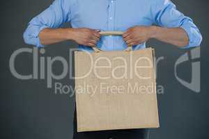 Man holding shopping bag against grey background