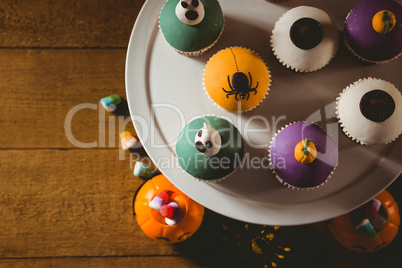 Overhead view of cup cakes with decorations on table during Halloween