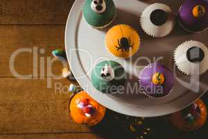 Overhead view of cup cakes with decorations on table during Halloween