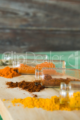 Various spices spilling out of bottles