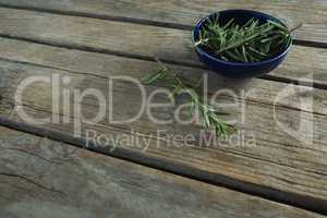 Rosemary in bowl on wooden table