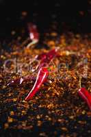 Red chilli flakes against black background