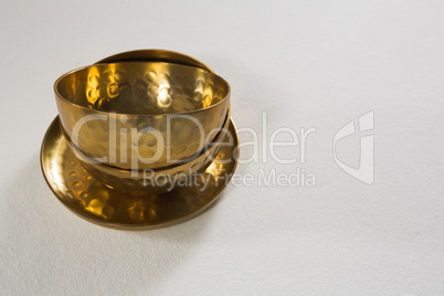 Golden steel bowls and plate on white background