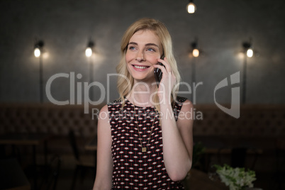 Woman talking on mobile phone in restaurant