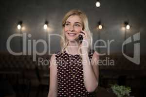 Woman talking on mobile phone in restaurant