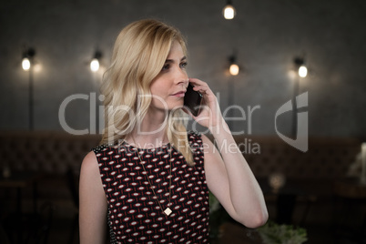 Woman talking on mobile phone in restaurant